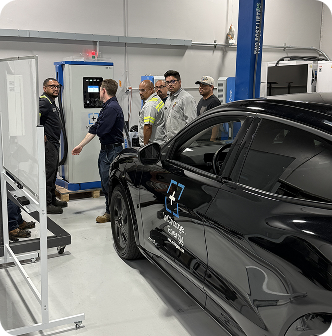 Hands-on EV charger training in automotive bay